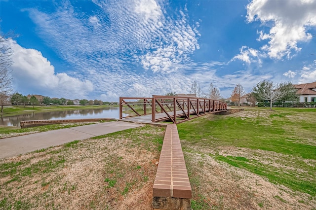 view of dock featuring a water view and a lawn