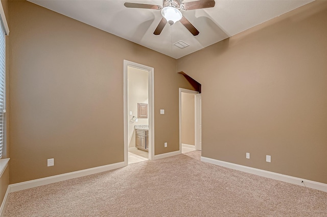 spare room with a ceiling fan, light colored carpet, visible vents, and baseboards