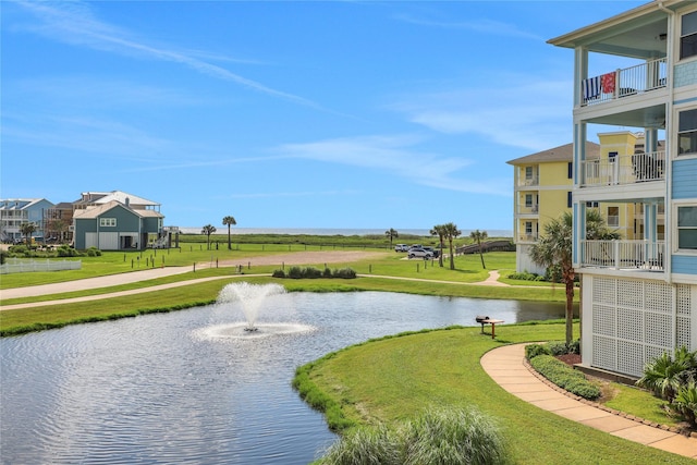 view of community featuring a lawn and a water view