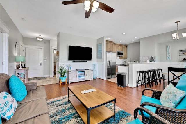 living room with light hardwood / wood-style flooring and ceiling fan