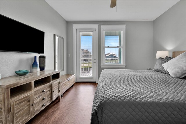 4121 Pointe W Dr Unit 102, Galveston, TX 77554 - bedroom with access to outside, dark wood finished floors, and a ceiling fan