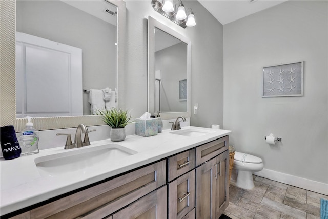 4121 Pointe W Dr Unit 102, Galveston, TX 77554 - full bath with baseboards, toilet, stone finish floors, and double vanity