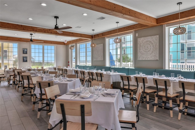 dining space featuring hardwood / wood-style floors, plenty of natural light, beamed ceiling, and ceiling fan