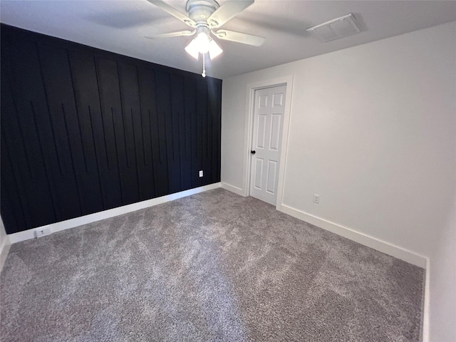 carpeted spare room featuring ceiling fan