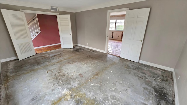 unfurnished room with crown molding and concrete flooring