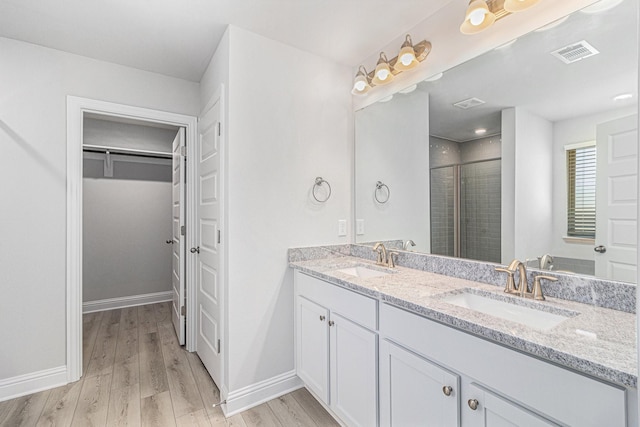 bathroom featuring hardwood / wood-style flooring, vanity, and a shower with shower door