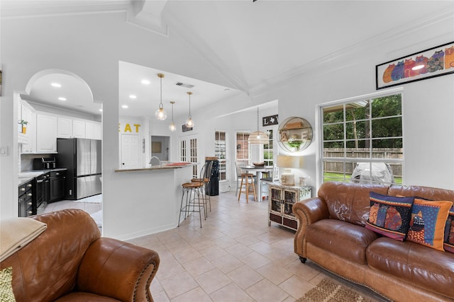 living room featuring ornamental molding, vaulted ceiling with beams, and light tile patterned floors