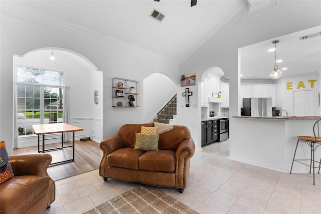 tiled living room featuring crown molding and lofted ceiling