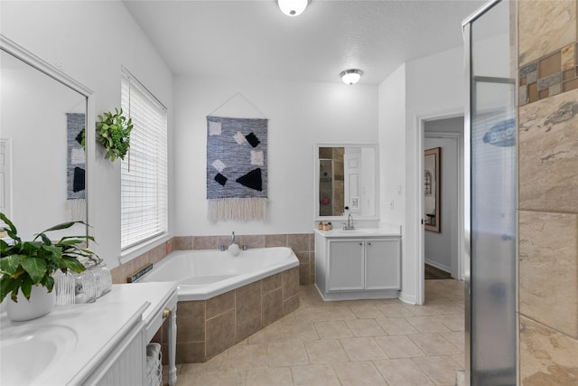 bathroom with vanity, separate shower and tub, tile patterned floors, and a textured ceiling