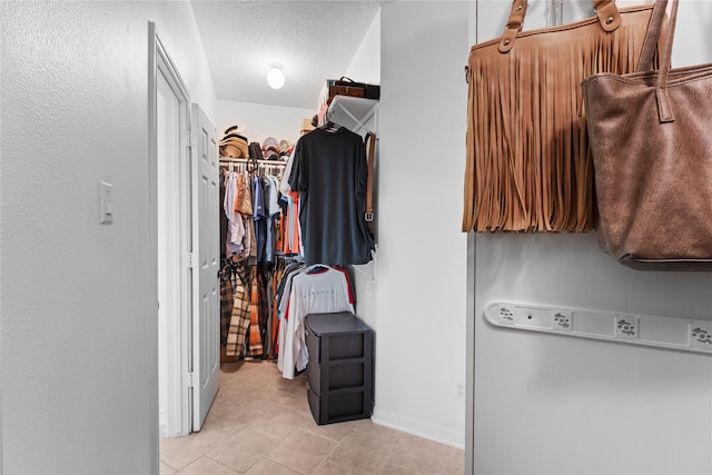 spacious closet with light tile patterned floors