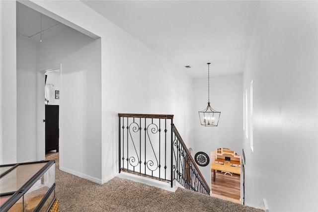 stairs with an inviting chandelier and carpet