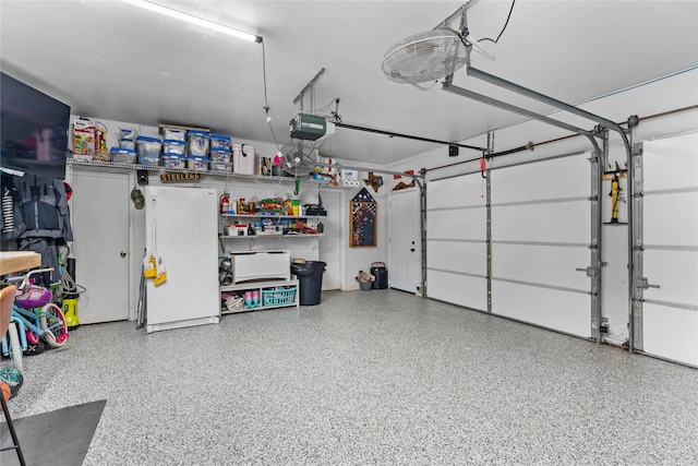 garage with white refrigerator and a garage door opener