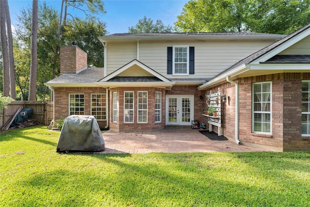 back of property with a yard, a patio area, and french doors