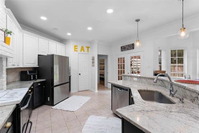 kitchen featuring sink, white cabinetry, light stone counters, appliances with stainless steel finishes, and pendant lighting