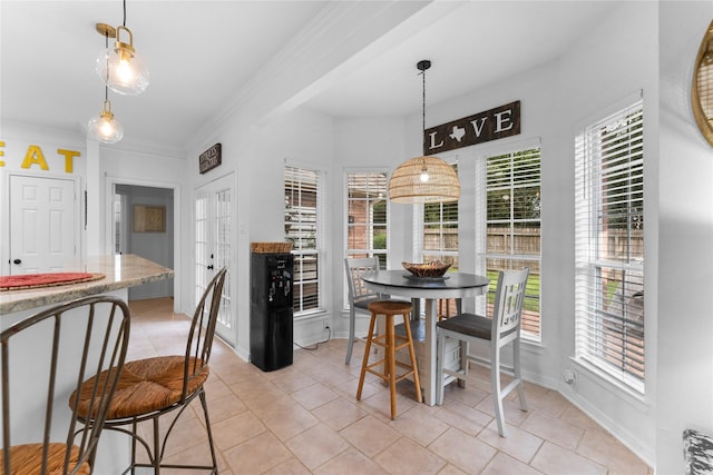 tiled dining area featuring crown molding and a healthy amount of sunlight