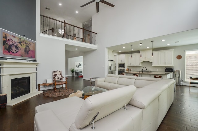 living room featuring dark hardwood / wood-style flooring, sink, and ceiling fan