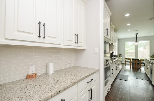 kitchen featuring white cabinetry, light stone counters, pendant lighting, and appliances with stainless steel finishes