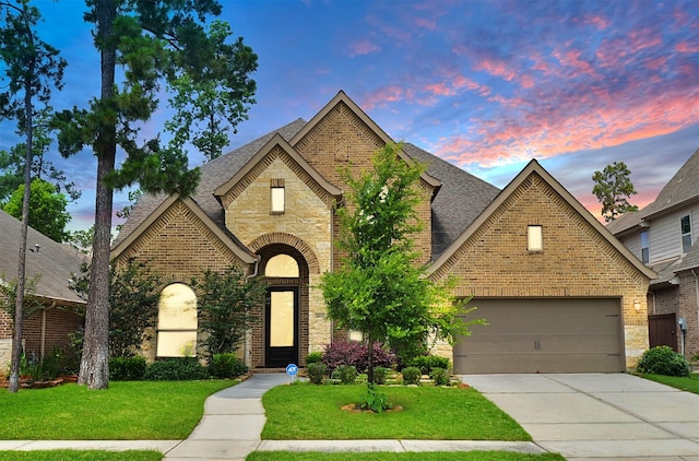 view of front of home featuring a garage and a lawn