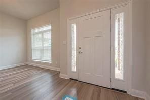 entryway featuring baseboards and wood finished floors