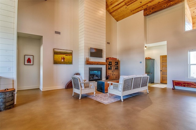 living area featuring finished concrete floors, high vaulted ceiling, and visible vents
