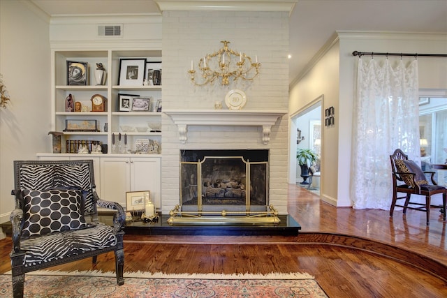 sitting room with wood-type flooring, ornamental molding, and a fireplace