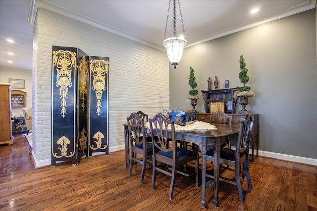 dining room with crown molding, dark hardwood / wood-style floors, and brick wall