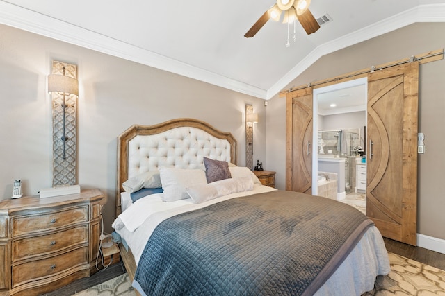 bedroom with light wood finished floors, a barn door, visible vents, vaulted ceiling, and crown molding