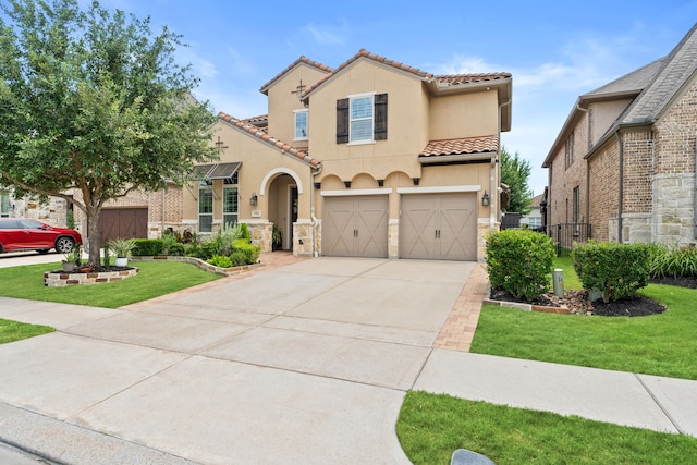 mediterranean / spanish-style home featuring a tiled roof, a garage, concrete driveway, and a front lawn