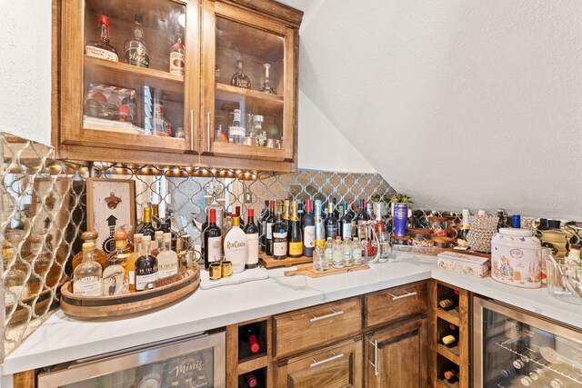 bar featuring wine cooler, decorative backsplash, and lofted ceiling