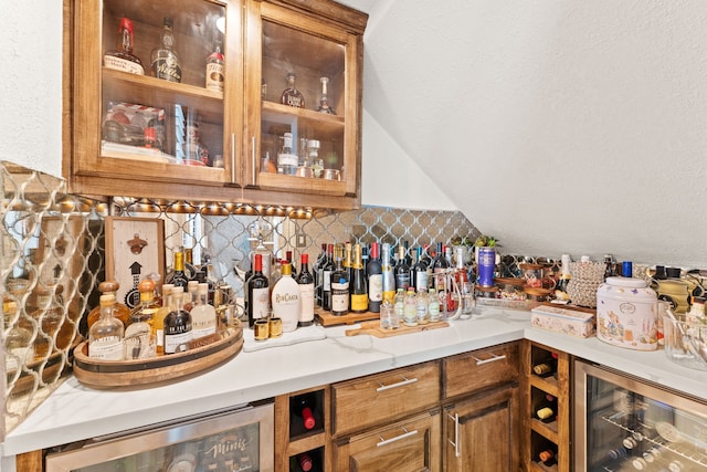 bar with decorative backsplash, lofted ceiling, beverage cooler, and a dry bar