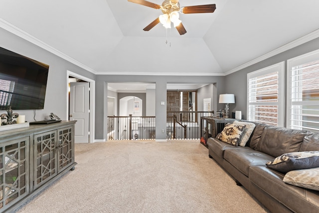 carpeted living room with crown molding, vaulted ceiling, and ceiling fan