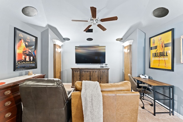 carpeted cinema room featuring a ceiling fan, decorative columns, and baseboards