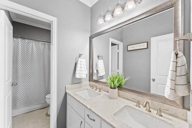 bathroom with toilet, crown molding, and a sink