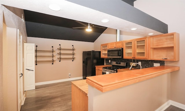 kitchen featuring lofted ceiling, butcher block counters, wood-type flooring, kitchen peninsula, and stainless steel appliances