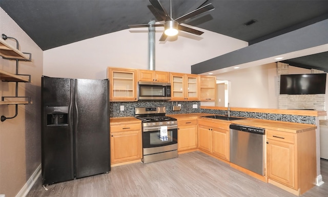 kitchen with stainless steel appliances, sink, light wood-type flooring, and decorative backsplash