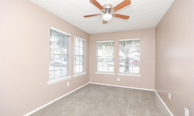 carpeted spare room featuring ceiling fan