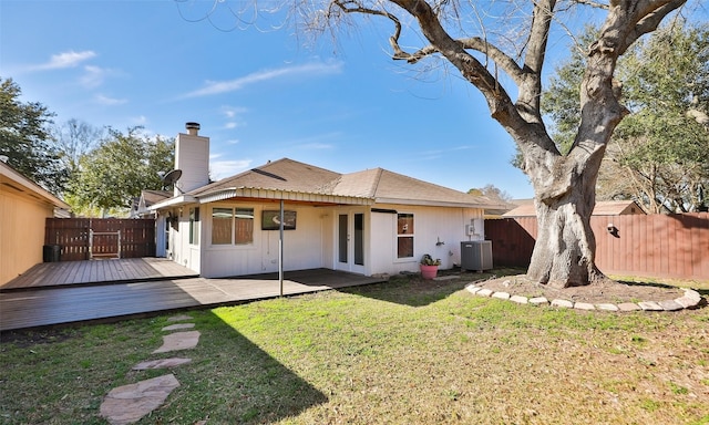 back of house with a wooden deck, a yard, and central AC