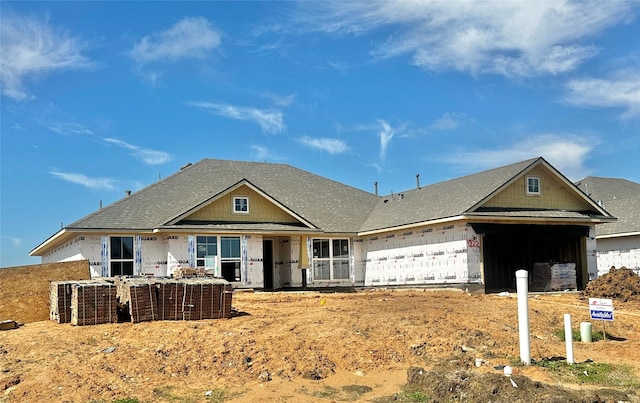 property in mid-construction with a shingled roof