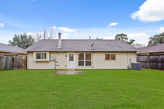 back of house featuring cooling unit, a patio, and a lawn