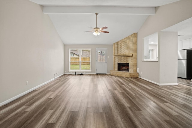 unfurnished living room with dark hardwood / wood-style floors, high vaulted ceiling, ceiling fan, a brick fireplace, and beam ceiling