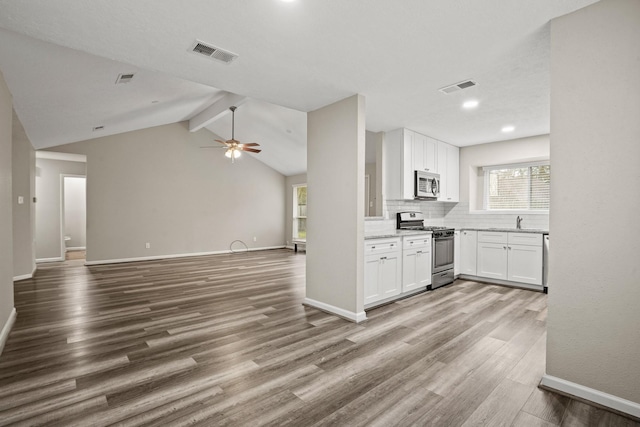 kitchen with stainless steel appliances, wood-type flooring, and white cabinets