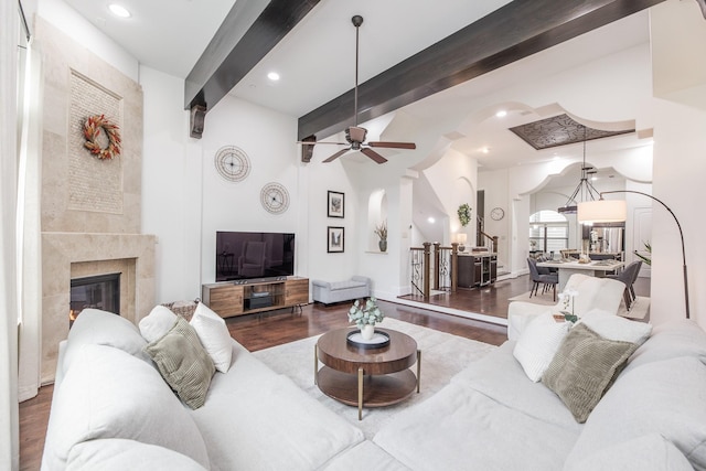 living room featuring hardwood / wood-style flooring, a high end fireplace, and beamed ceiling