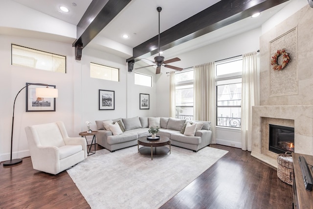 living room with dark wood-type flooring, a healthy amount of sunlight, and beamed ceiling