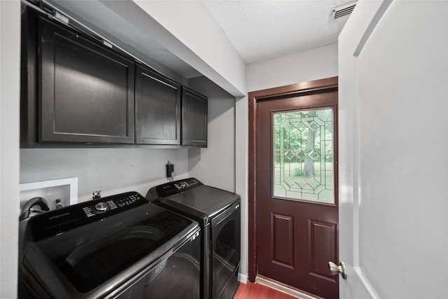 washroom featuring visible vents, wood finished floors, cabinet space, a textured ceiling, and independent washer and dryer