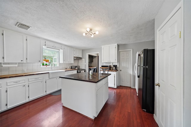 kitchen with visible vents, freestanding refrigerator, electric range, white cabinets, and dark wood-style flooring