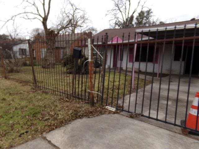 view of gate with a carport and a yard