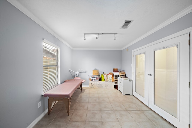 interior space with rail lighting, ornamental molding, light tile patterned floors, a textured ceiling, and french doors