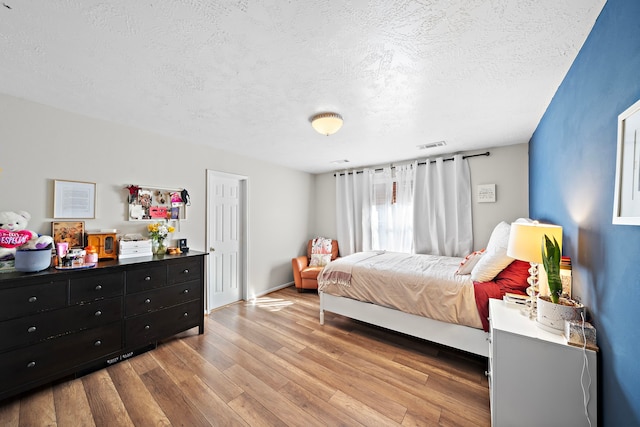 bedroom featuring hardwood / wood-style flooring and a textured ceiling