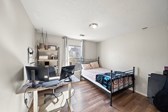 bedroom with wood-type flooring and a textured ceiling