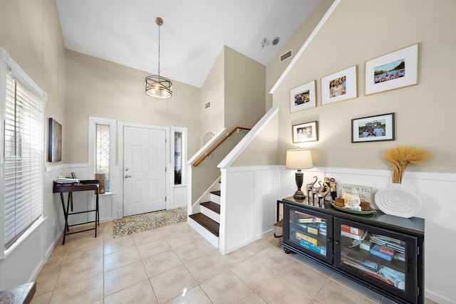 tiled foyer featuring high vaulted ceiling